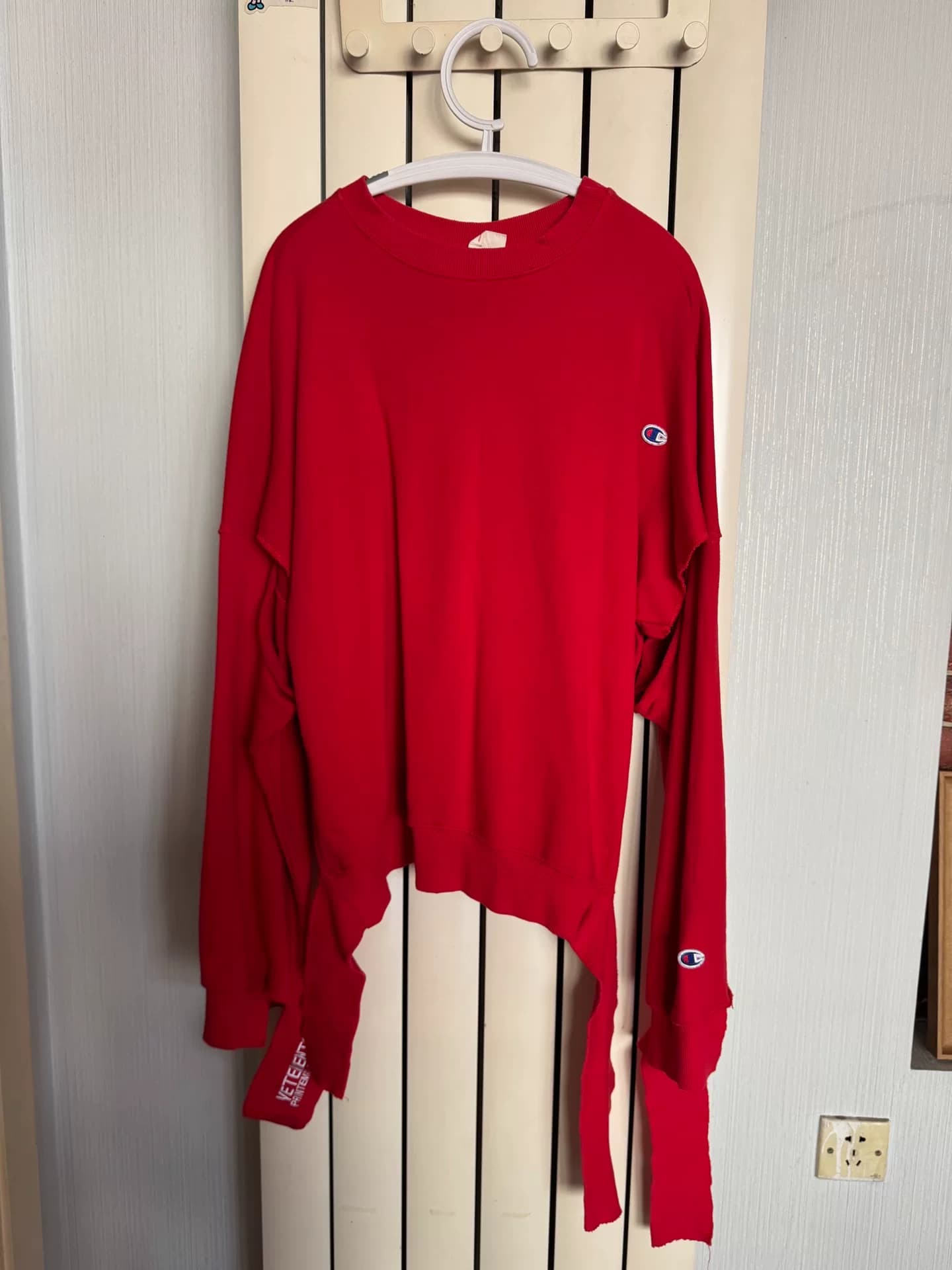 Красный свитер с кобрендингом Vetements x Champion, свободного кроя, с открытыми подмышками, рукава с надписью Vetements, маленький логотип Champion…