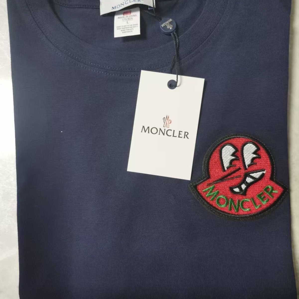 Совершенно новая футболка Moncler с завязанными глазами и короткими рукавами, темно-синяя с красными бирками на груди.