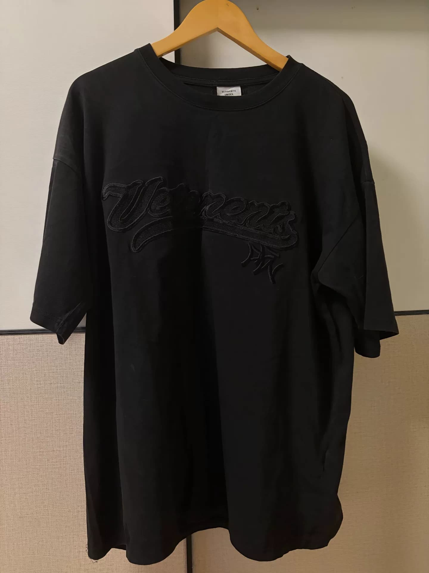 черная футболка с коротким рукавом, вышитая слоганом vetements