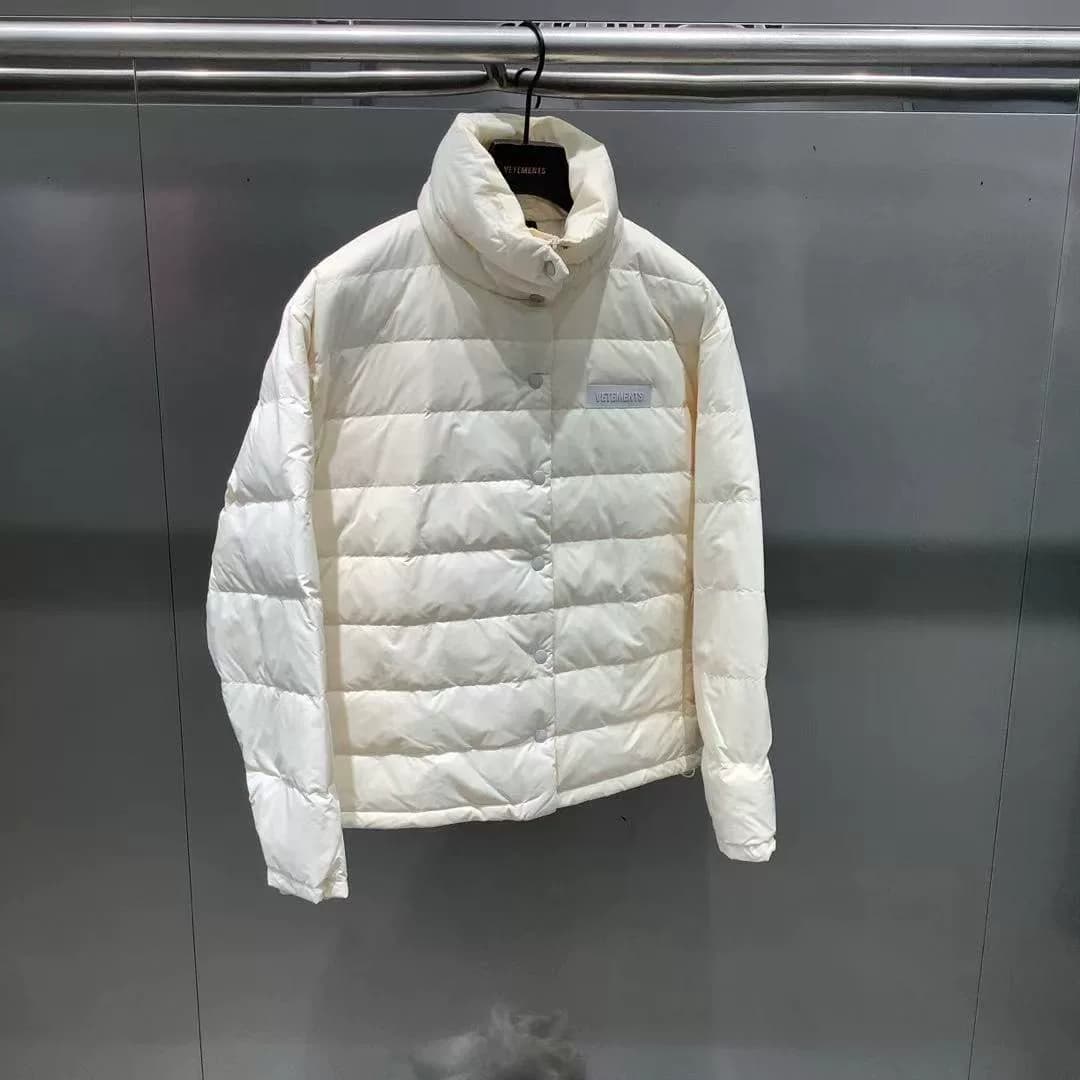Симпатичный пуховик VETEMENTS доступен в белоснежном и темно-синем цветах.Простой воротник-стойка